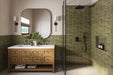 Bathroom setting featuring Atlas Verde Mini Brick 5x15cm gloss wall tiles, laid in a horizontal brick format to introduce depth and rhythm across the space. The rich green tone and reflective gloss finish enhance light and movement, creating a confident yet calming backdrop.