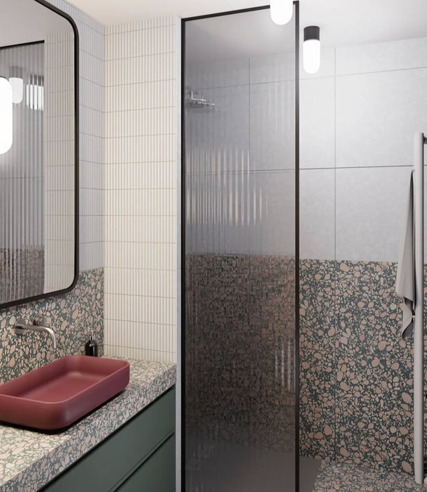 Bathroom featuring Chunks POP Terrazzo Green 60x120cm porcelain wall and floor tiles, showcasing a terrazzo effect surface with green base and pink fragments, paired with fluted wall tiles, a floating vanity, and a contemporary finish.