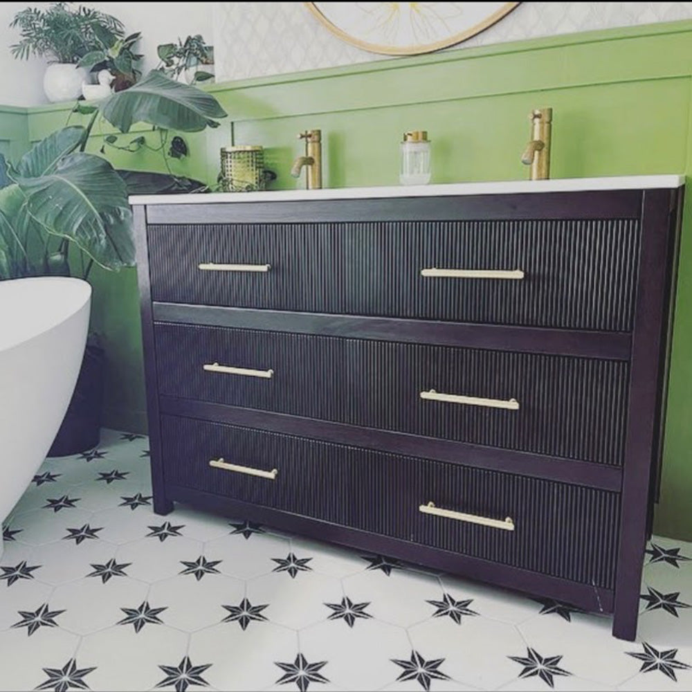 Bathroom setting featuring Pole Star Black Moroccan-style 22x25cm hexagon patterned porcelain floor tiles, paired with a dark wood vanity, brass fittings, and green wall panelling.