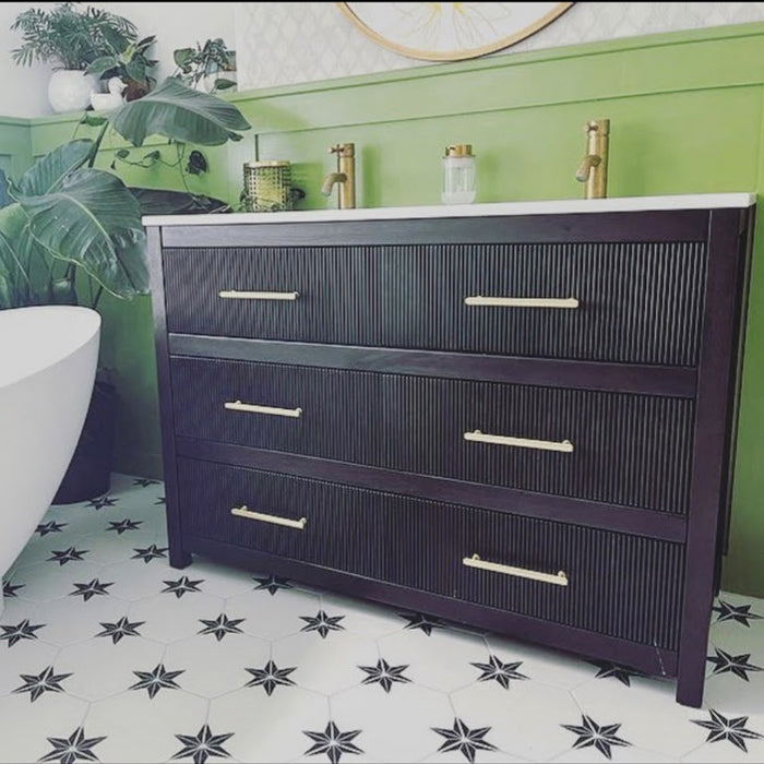 Bathroom setting featuring Pole Star Black Moroccan-style 22x25cm hexagon patterned porcelain floor tiles, paired with a dark wood vanity, brass fittings, and green wall panelling.