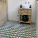 Bathroom featuring Agraba Verde 20x20cm Moroccan-style patterned floor tiles in green and white, paired with a rustic wooden vanity, white panelled walls, and modern brass fittings for a natural, artisan-inspired look.