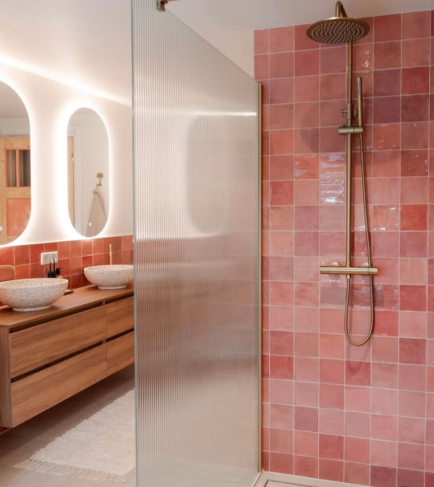 Zellij Rose Pink Square tiles, 13.2cm x 13.2cm, Moroccan style square tiles in soft rose pink tones with natural colour variation and glossy glazed finish, installed on a bathroom shower wall for a warm, handcrafted look.