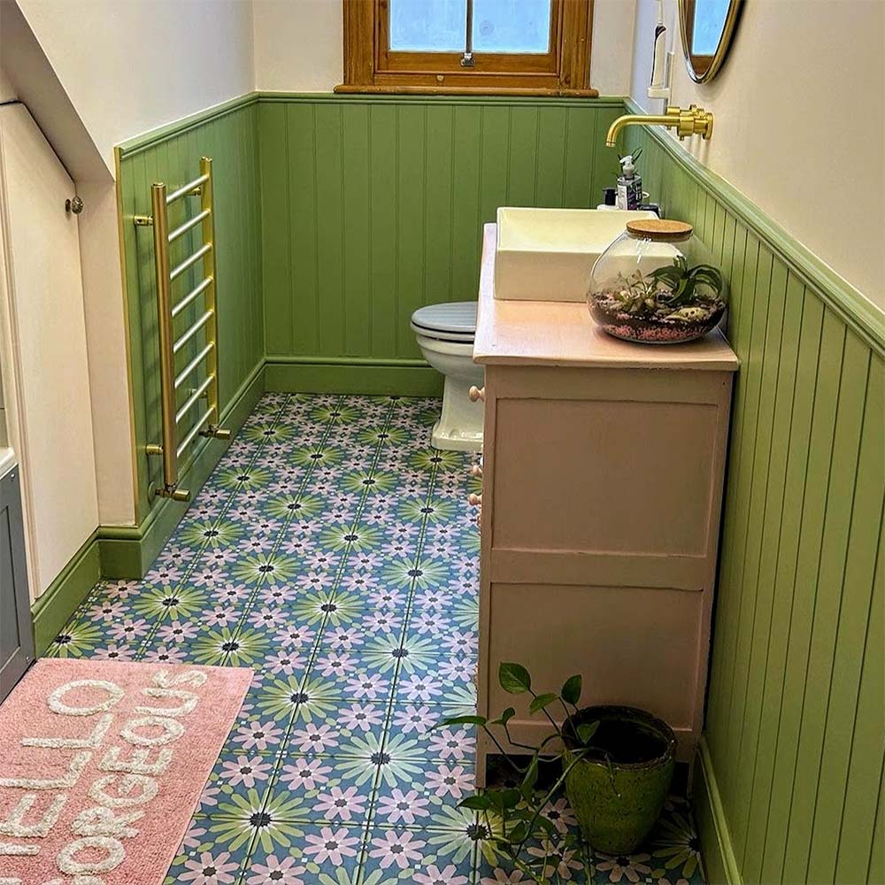 Bathroom featuring Fizaan Summer Moroccan-style 20×20cm porcelain floor tiles, showcasing a blue, green and pink geometric pattern paired with green panelling and brass fittings.