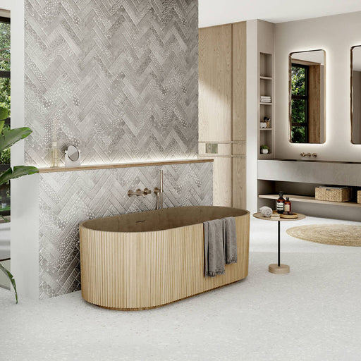 Bathroom featuring Confetti White 66×66cm terrazzo-style porcelain floor tiles with subtle white and light grey chips, styled with a wood-slatted freestanding bath, herringbone textured wall tiles, built-in shelving, and warm neutral décor for a serene modern spa look.