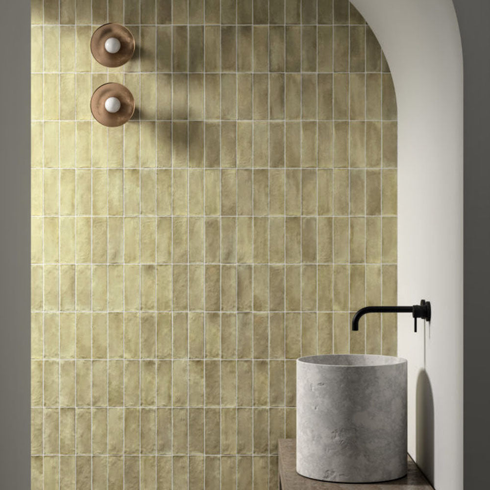 Zellij Weald Green Brick Moroccan Style 6.5cm x 20cm, slim brick wall tiles in soft weald green tones with natural tonal variation, glossy glazed finish, and handcrafted Moroccan-inspired design, styled in an arched bathroom setting for a warm, organic look.