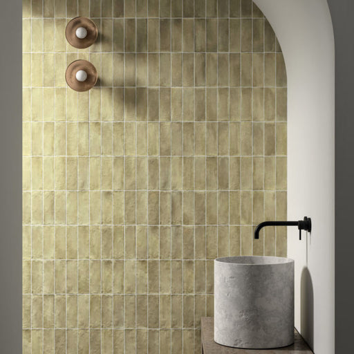 Zellij Weald Green Brick Moroccan Style 6.5cm x 20cm, slim brick wall tiles in soft weald green tones with natural tonal variation, glossy glazed finish, and handcrafted Moroccan-inspired design, styled in an arched bathroom setting for a warm, organic look.
