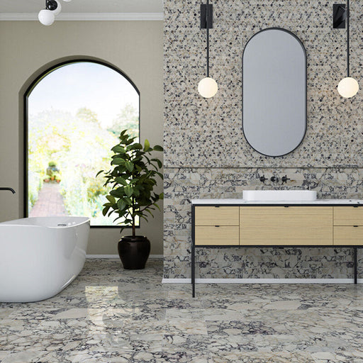 Bathroom interior featuring Fitzrovia Picasso 5 x 20cm honed natural marble tiles, installed across the wall in a linear layout, showcasing intricate multi-tonal veining, paired with matching large-format marble floor tiles, a wood vanity unit, and soft architectural details for a refined, design-led space.