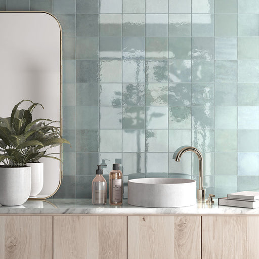 Zellij Aqua Blue Square Moroccan Style tiles, 13.2cm x 13.2cm, square format, soft aqua blue tones with natural tonal variation, glossy glazed finish, handcrafted Moroccan-inspired design shown in a contemporary bathroom wall setting.