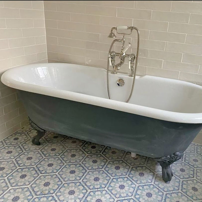 Maroush Frost Blue 18.7x21.6cm Moroccan hexagonal tiles with a soft blue and white floral geometric pattern, used as a bathroom floor beneath a freestanding clawfoot bathtub and light cabinetry.