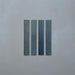 Close-up of Belem Blue 5cm x 30cm artisanal porcelain wall tiles, displaying four slim brick tiles with varied blue and blue-green tones, subtle texture and gentle tonal variation.