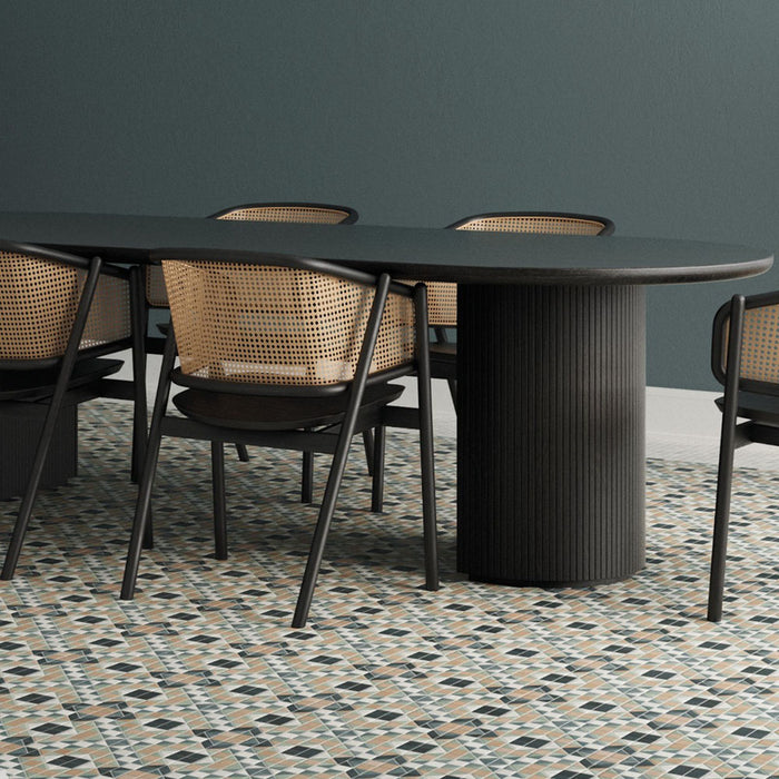 Dining area featuring Belgravia Marina Plus Mosaic 28 × 28cm Victorian style patterned floor tiles, with intricate geometric detailing in muted blue, green and beige tones, paired with a dark wood table, woven chairs, and deep green walls.