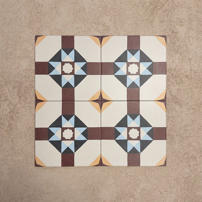 Four Europa Berlin 20x20cm Victorian Moroccan style tiles arranged together to showcase the repeating geometric star pattern in burgundy, blue, mustard and cream tones, displayed against a textured beige background.