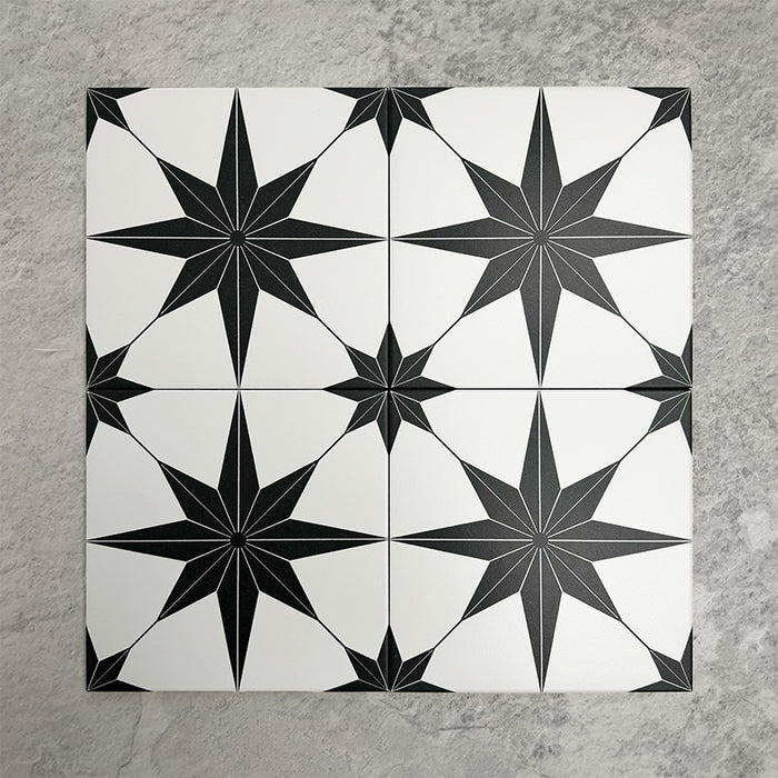 Pole Star Black Moroccan-style 25x25cm patterned porcelain tiles arranged in a grouped layout, showcasing the bold black star motif across a crisp white background.