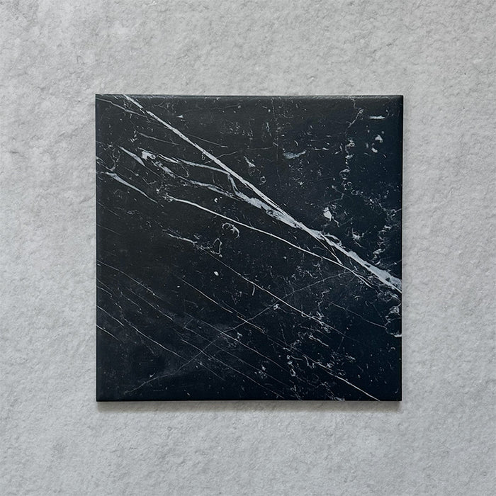 Calacatta Nero Black marble-effect 25×25cm porcelain tile featuring a deep black base with striking white veining, ideal for creating bold, elegant floors and walls in modern and classic interiors.