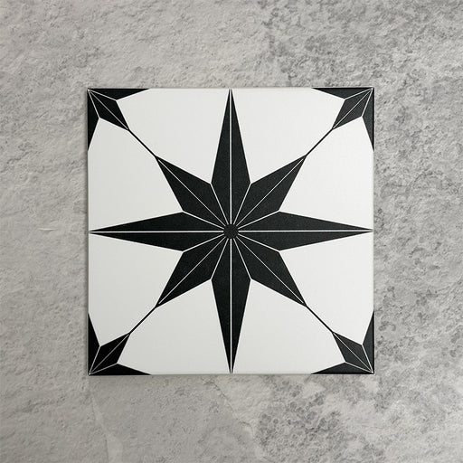 Pole Star Black Moroccan-style 25x25cm patterned porcelain tile, featuring a bold black star motif on a crisp white background.