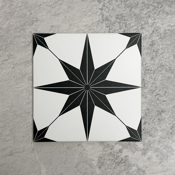 Pole Star Black Moroccan-style 25x25cm patterned porcelain tile, featuring a bold black star motif on a crisp white background.