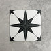 Pole Star Black Moroccan-style 25x25cm patterned porcelain tile, featuring a bold black star motif on a crisp white background.