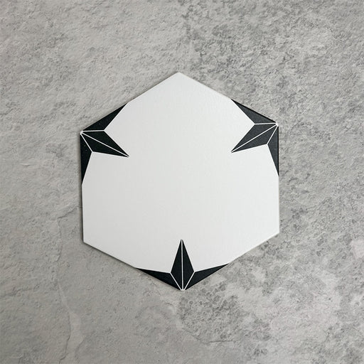 Pole Star Black Moroccan-style 22x25cm hexagon patterned porcelain tile, featuring a crisp white centre with black geometric corner detailing.