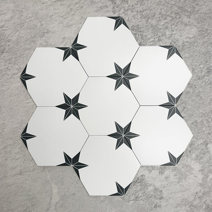 Pole Star Black Moroccan-style 22x25cm hexagon patterned porcelain tiles arranged in a grouped layout, showcasing the repeating black star motif across a crisp white surface.
