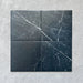 Four Calacatta Nero Black marble-effect 25×25cm porcelain tiles showing natural white veining variation on a deep black base, ideal for creating a bold, authentic marble look across floors and walls.