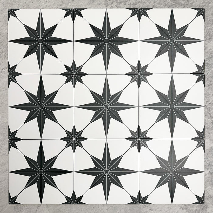 Pole Star Black Moroccan-style 25x25cm patterned porcelain tiles arranged in a grouped layout, showcasing the bold black star motif across a crisp white background.