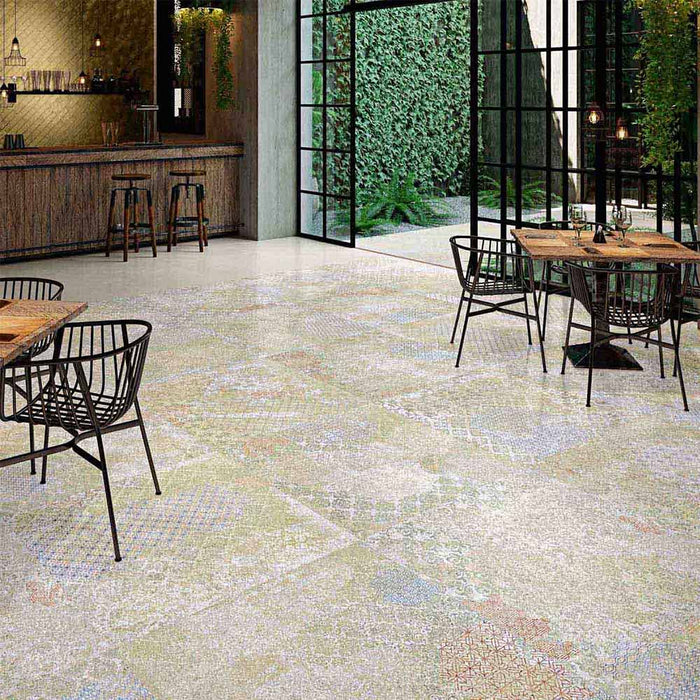 Open-plan dining space featuring Boheme Blend 60 × 60cm patterned porcelain floor tiles, combining soft, aged-effect tones with subtle decorative detailing. Paired with warm wood and black accents for a relaxed, contemporary finish.