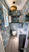 Bathroom featuring Bloom Azul Blue 20x20cm Moroccan-style wall tiles in soft blue, cream and charcoal tones, styled with contemporary sanitaryware, light wood flooring, brass lighting, and modern shelving.