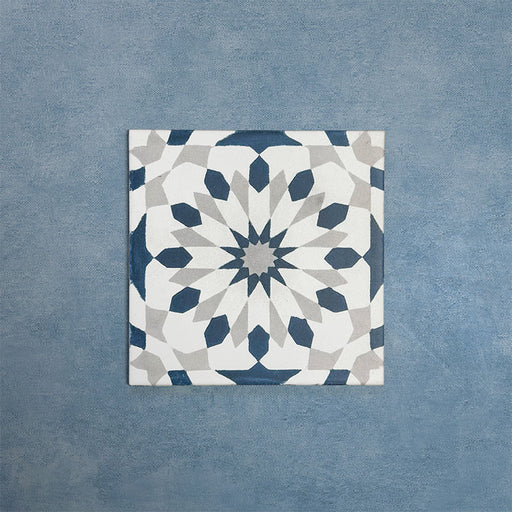 Soukaina Blue A 20cm x 20cm Moroccan-style patterned porcelain tile, featuring a geometric star design in deep blue, white and soft grey tones with a matt finish.