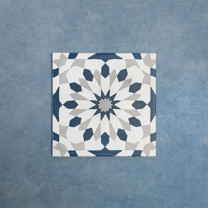 Soukaina Blue A 20cm x 20cm Moroccan-style patterned porcelain tile, featuring a geometric star design in deep blue, white and soft grey tones with a matt finish.