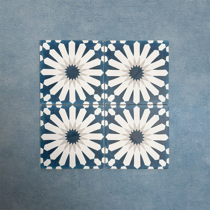 Group of Soukaina Blue B Moroccan-style 20cm x 20cm patterned porcelain tiles, showing a repeating central star design in deep blue, white and soft grey tones with a matt finish.