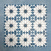 Group of Soukaina Blue D Moroccan-style 20cm x 20cm patterned porcelain tiles, showing a repeating central star motif in deep blue, white and soft neutral tones with a matt finish.