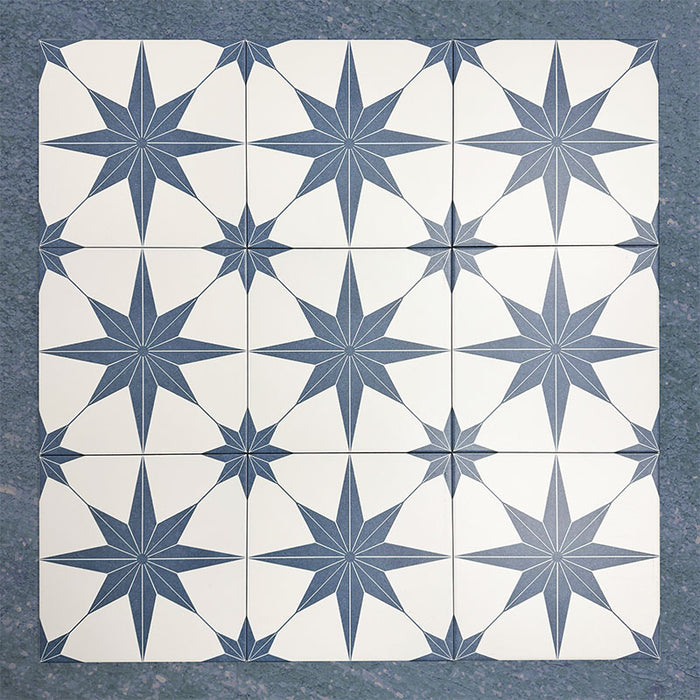 Pole Star Blue Moroccan-style 25x25cm patterned porcelain tiles arranged in a grouped layout, showcasing the repeating blue star motif on a soft white background.