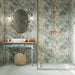 Boheme Blue Patterned 59.55cm x 59.55cm floor tiles, featuring a soft blue-grey finish with subtle decorative patterning, paired with tropical botanical wall tiles and warm brass details in a nature-inspired bathroom.