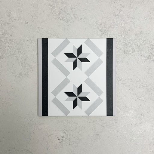 Georgetown Star Border Victorian-style 20x20cm patterned porcelain tile, featuring a monochrome star motif with contrasting black and grey border detailing.