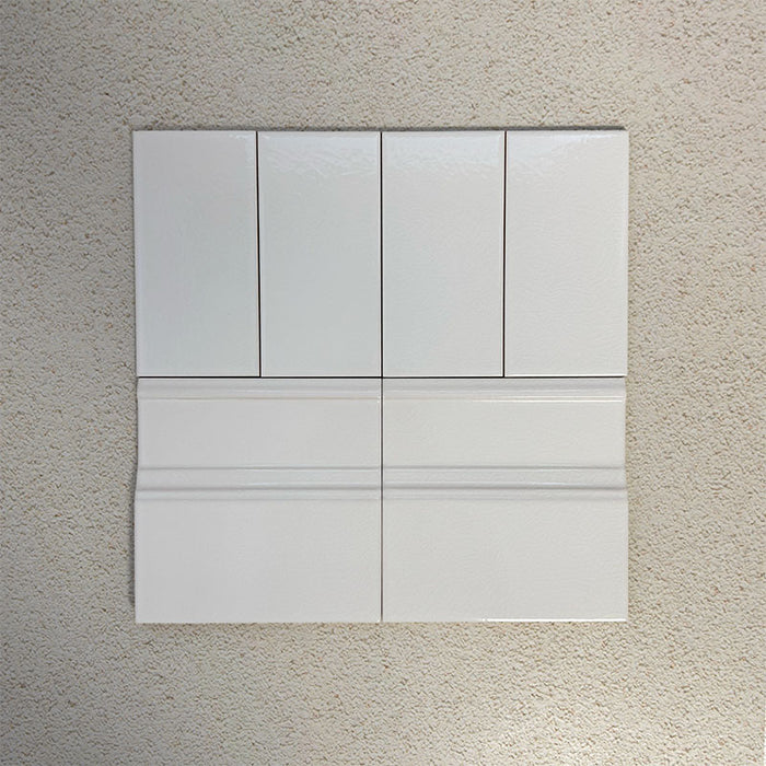 Flat lay showing Finchley White 7.5 × 15cm ceramic wall tiles with a crackle glaze finish, paired with matching 15 × 15cm skirting tiles to create a classic, cohesive wall and floor tile detail.