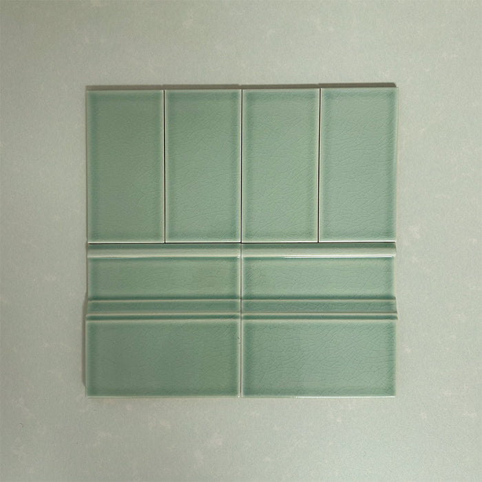 Flat lay showing Finchley Lime Green 7.5 × 15cm ceramic wall tiles with a crackle glaze finish, paired with matching 15 × 15cm skirting tiles to create a classic, cohesive wall and floor tile detail.