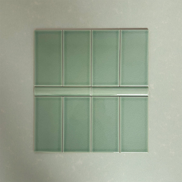 Flat lay showcasing Finchley Lime Green 7.5 × 15cm ceramic wall tiles with a crackle glaze finish, paired with matching 2.5 × 15cm pencil trim to create a refined, classic brick-style wall tile layout.