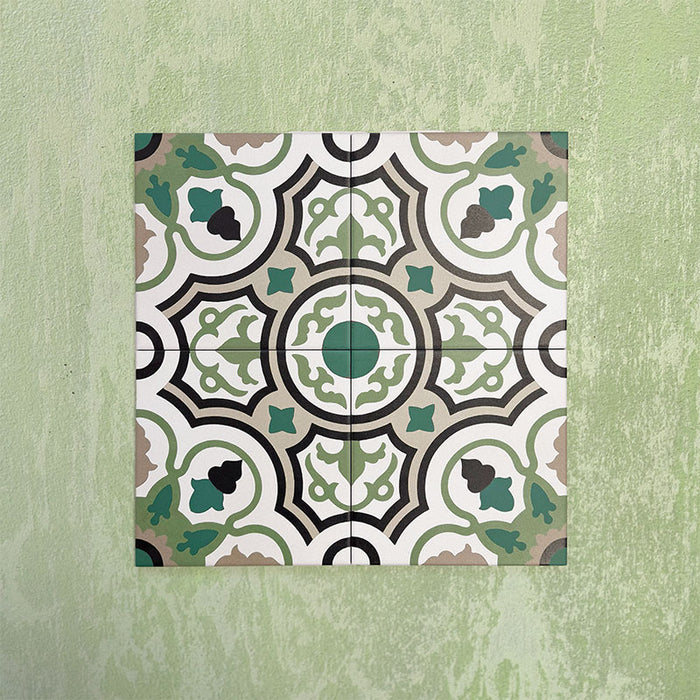 Four Europa Budapest 20x20cm Victorian Moroccan style tiles displayed together against a textured green wall, forming a symmetrical geometric pattern in green, cream, black and taupe tones in a styled product setting.