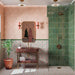 Bathroom featuring Cabana Paradise 20x20cm Moroccan-style patterned wall and floor tiles, with colourful floral motifs in pink and green, paired with forest green shower tiles, textured pink walls and brass fixtures.