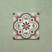 Cabana Paradise 20x20cm Moroccan-style ceramic tile shown as a single piece, featuring a multicolour floral pattern with pink, green, and mustard tones on a soft green background.