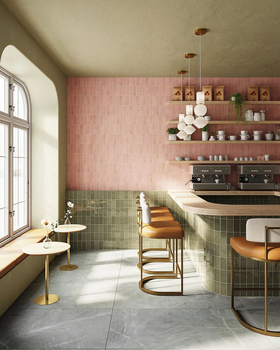 Café interior featuring Atlas Pink Mini Brick 5x15cm matt wall tiles, laid in a vertical brick format to emphasise height and create a soft, rhythmic backdrop. The muted pink tone introduces warmth without overwhelming the space, while the matt finish keeps the overall look refined and understated.