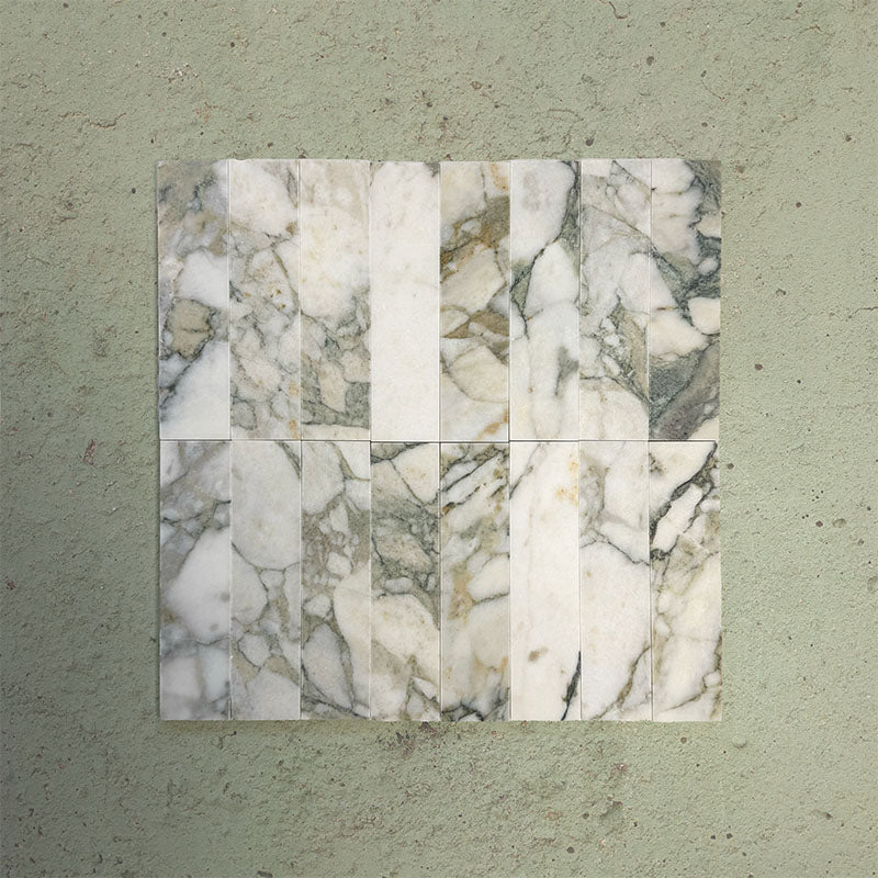Grouped Fitzrovia Calacatta Green 5 x 20cm honed natural marble tiles arranged together to showcase the full variation of the range, featuring a soft white base with flowing grey and green veining and subtle warm undertones, highlighting the natural character across multiple pieces.
