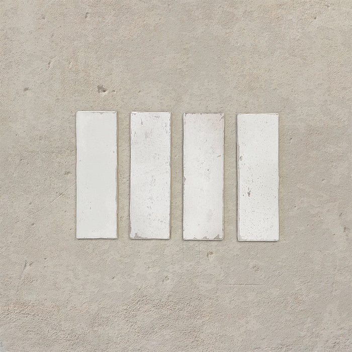 Close-up of Fusion Bricks Chalk White 6.5x20cm brick wall tiles, showcasing soft white tones with subtle tonal variation and a lightly textured surface, highlighting a clean, handcrafted finish.