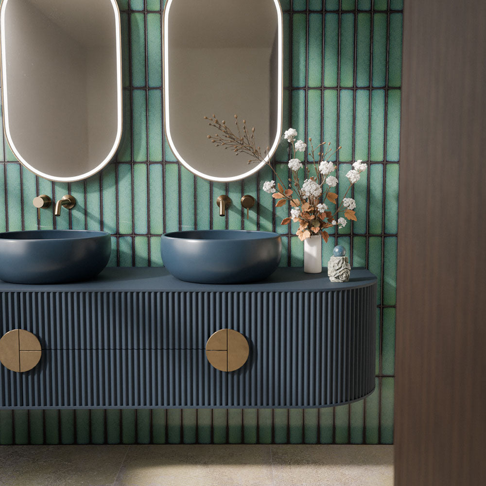 Chemistry Green 6.5cm x 30cm wall tiles, featuring rich green tones and dark edging behind a statement double vanity with deep blue basins, fluted cabinetry and brass details.