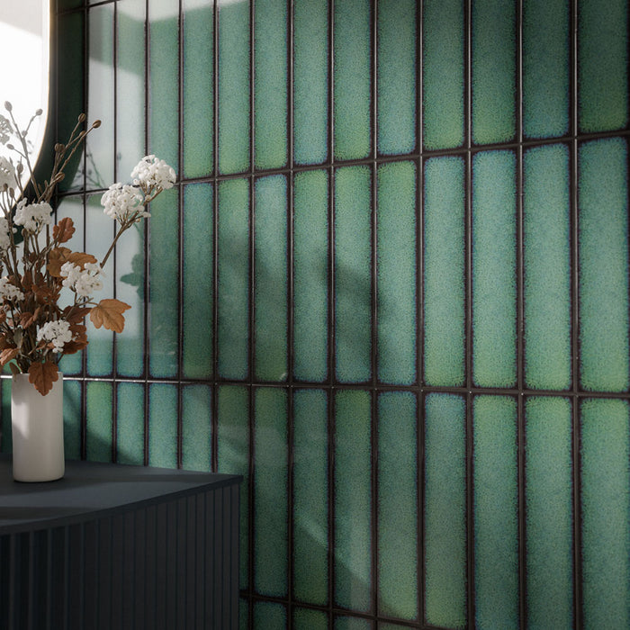 Chemistry Green 6.5cm x 30cm wall tiles, showcasing vibrant green tones, dark contrasting edges and a glossy finish that catches the natural light.