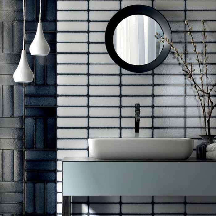 Bathroom setting featuring Chemistry White 6.5cm x 30cm rectangular ceramic wall tiles, installed in a stacked layout with a glossy crackle-effect white glaze and dark grout for a contemporary, artisan finish.