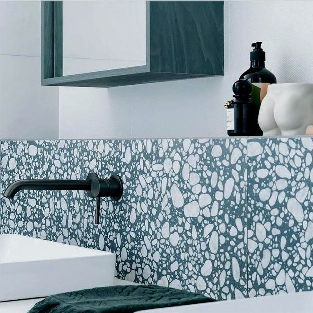 Modern bathroom featuring Chunks POP Terrazzo Blue 60 × 60cm terrazzo-effect porcelain wall tiles, styled with matte black brassware, crisp white surfaces, and contemporary accessories for a clean, playful interior look.
