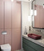 Modern bathroom featuring Chunks POP Terrazzo Green 60 × 120cm terrazzo-effect porcelain wall and floor tiles, paired with deep green cabinetry, a burgundy basin, ribbed glass shower screen, and soft contemporary lighting.