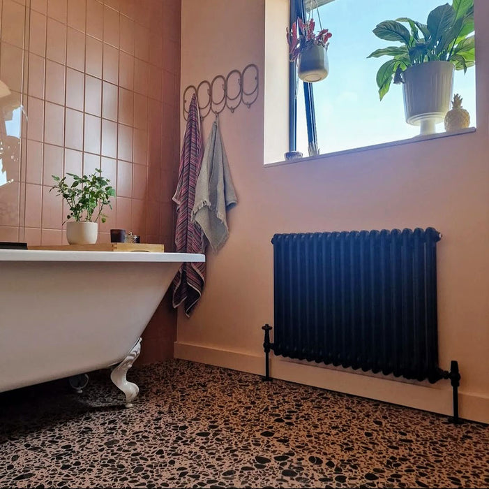 Bathroom featuring Chunks POP Terrazzo Pink 60 × 60cm terrazzo-effect porcelain floor tiles, paired with blush pink wall tiles, monochrome terrazzo shower walls, and a classic freestanding bath for a playful contemporary look.