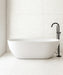 Minimalist bathroom featuring Chunks Pop White 60cm x 120cm terrazzo effect porcelain wall and floor tiles, paired with a freestanding bath and black brassware for a bright, contemporary spa-inspired interior.